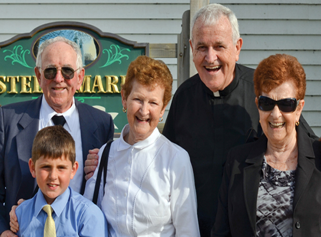 (Credit: Dante Carrer) Fr. Ambie MacKinnon with his brother Joe MacKinnon, grandnephew Calum, and sisters Jane Hayes and Margie MacKinnon on the 50th anniversary of his first solemn mass in Stella Maris parish, Inverness, Cape Breton, Nova Scotia.