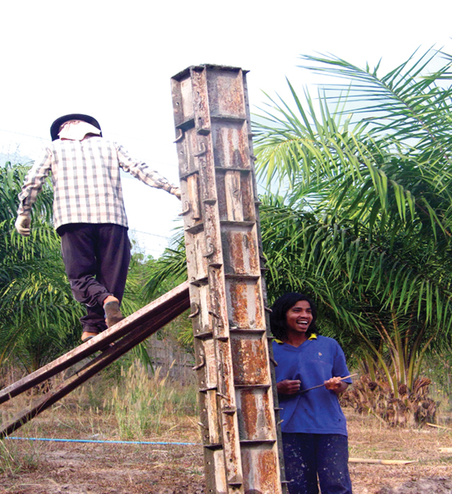 Construction workers at the Camillian Social Centre: Level (checked shirt) who, as his name implies, is fussy about things being level and is a good tradesman; and Onaday, a happy young man who often sings while he works. The majority of people in northern Thailand have nicknames.